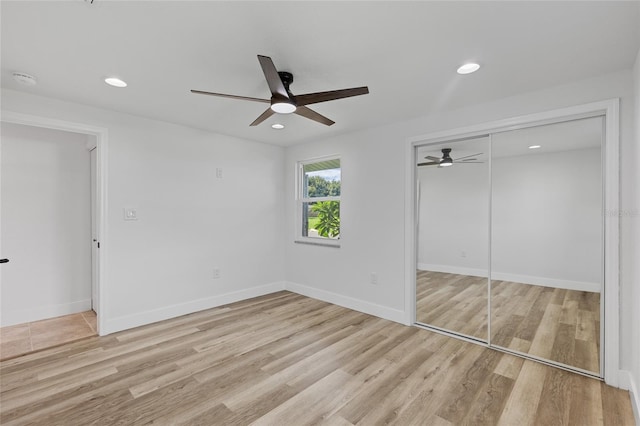 unfurnished bedroom featuring light hardwood / wood-style flooring, a closet, and ceiling fan