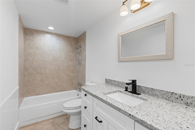 full bathroom featuring toilet, tiled shower / bath, vanity, and tile patterned flooring