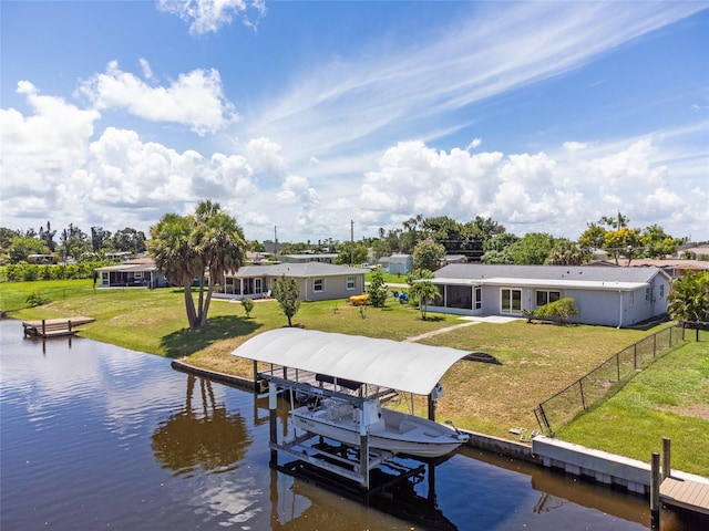 view of dock with a water view and a lawn