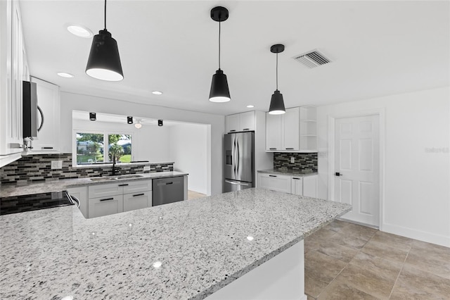 kitchen with sink, appliances with stainless steel finishes, kitchen peninsula, and white cabinets