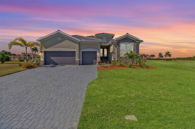 view of front of property featuring a garage and a yard