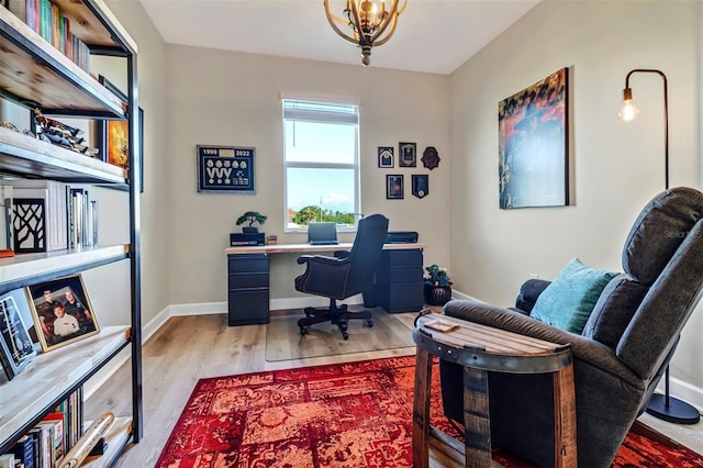 office featuring an inviting chandelier and light hardwood / wood-style flooring