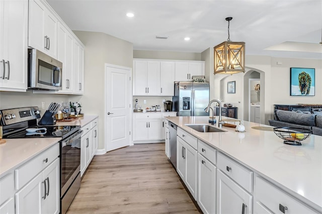 kitchen with sink, appliances with stainless steel finishes, light wood-type flooring, and white cabinets