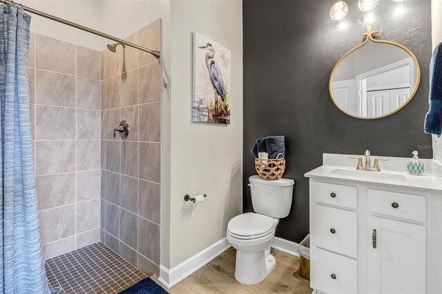 bathroom with walk in shower, hardwood / wood-style flooring, toilet, and vanity