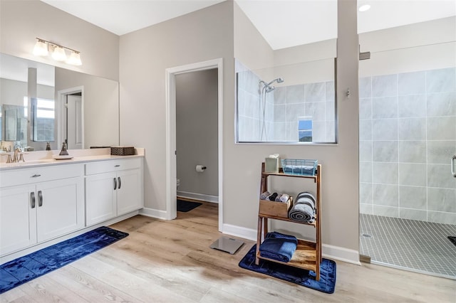 bathroom with vanity, a tile shower, and hardwood / wood-style floors