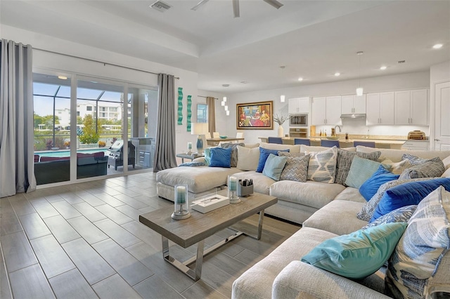 living room featuring ceiling fan and sink