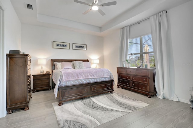 bedroom with a tray ceiling and ceiling fan