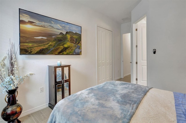 bedroom with light hardwood / wood-style flooring and a closet