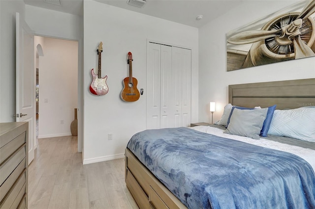 bedroom with light hardwood / wood-style flooring and a closet