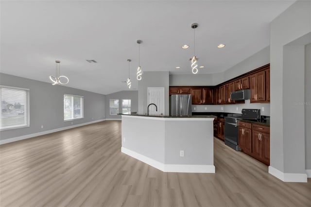 kitchen featuring stainless steel appliances, dark countertops, light wood-style floors, and baseboards