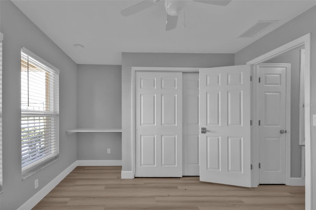 unfurnished bedroom with light wood finished floors, a closet, visible vents, ceiling fan, and baseboards