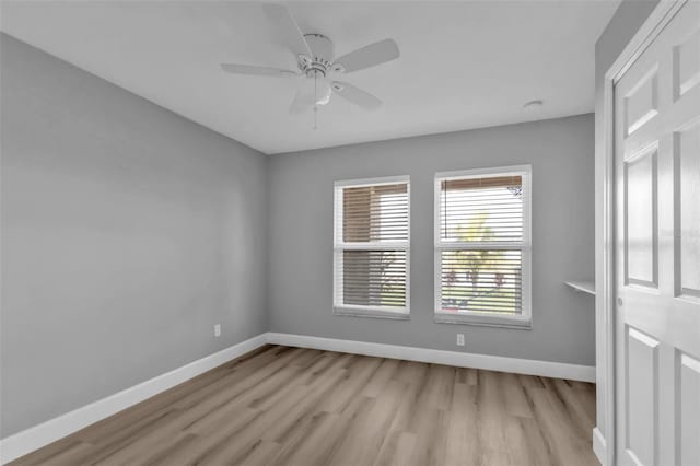 spare room featuring light wood-style floors, ceiling fan, and baseboards