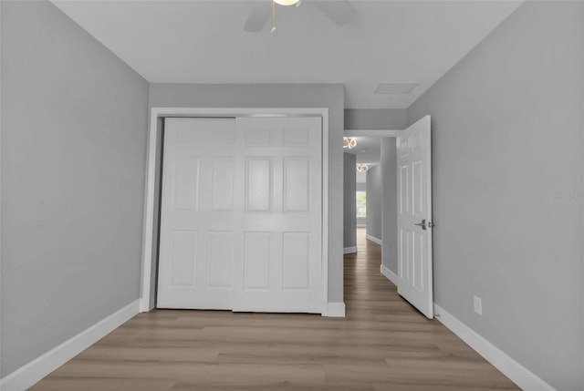 unfurnished bedroom with a closet, wood finished floors, and baseboards