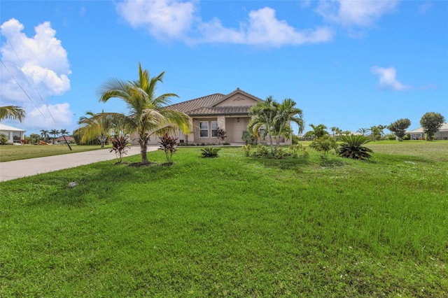 view of front of home featuring an attached garage, concrete driveway, and a front yard