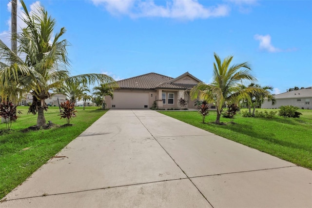 view of front of property with an attached garage, a tile roof, concrete driveway, stucco siding, and a front yard