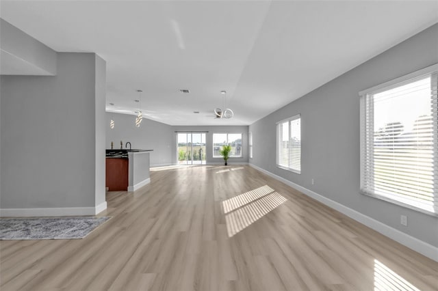 unfurnished living room featuring light wood-type flooring and baseboards