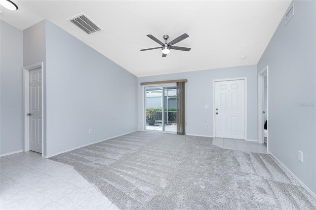 carpeted spare room featuring lofted ceiling and ceiling fan