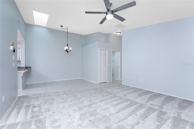 spare room with a skylight, carpet flooring, and ceiling fan with notable chandelier