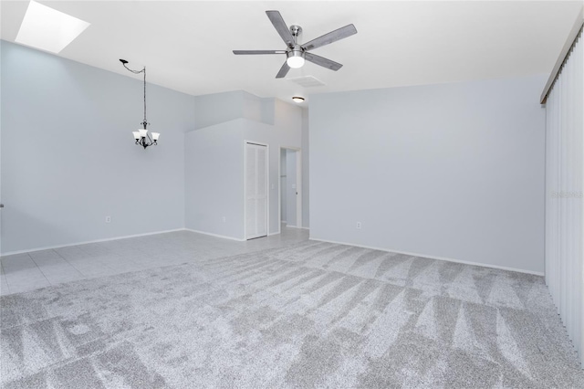 carpeted spare room with ceiling fan with notable chandelier