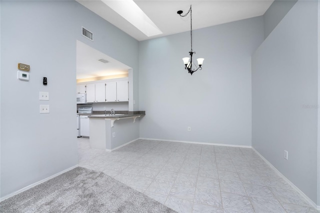 unfurnished living room with an inviting chandelier and light tile patterned floors