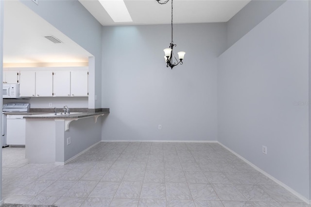 kitchen with a notable chandelier, light tile patterned floors, range, pendant lighting, and kitchen peninsula