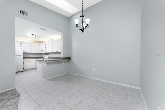 unfurnished dining area with light tile patterned floors and an inviting chandelier