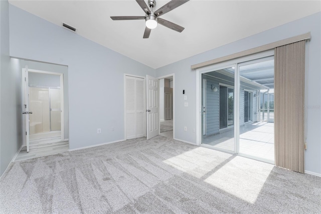 unfurnished bedroom featuring access to exterior, light carpet, a closet, and vaulted ceiling