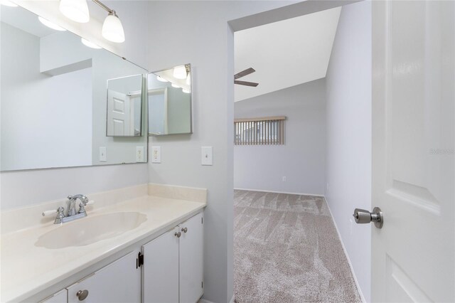 bathroom featuring vanity, ceiling fan, and vaulted ceiling