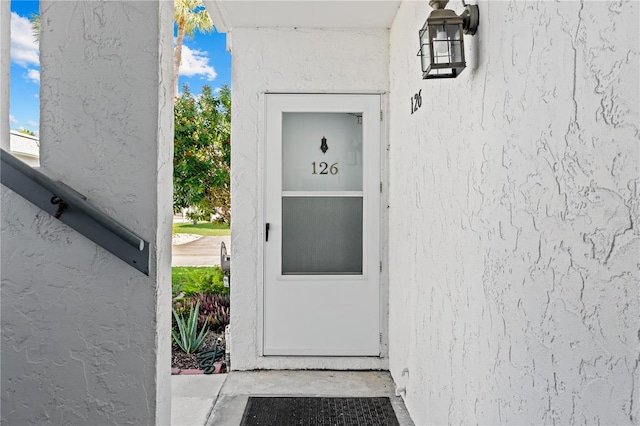 view of exterior entry featuring stucco siding