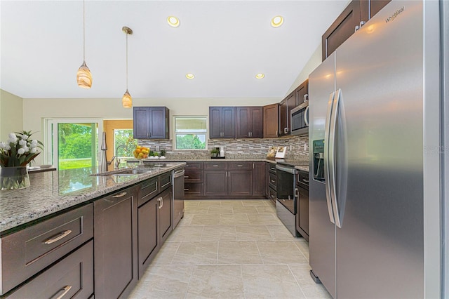 kitchen featuring appliances with stainless steel finishes, light stone counters, decorative light fixtures, light tile patterned floors, and decorative backsplash