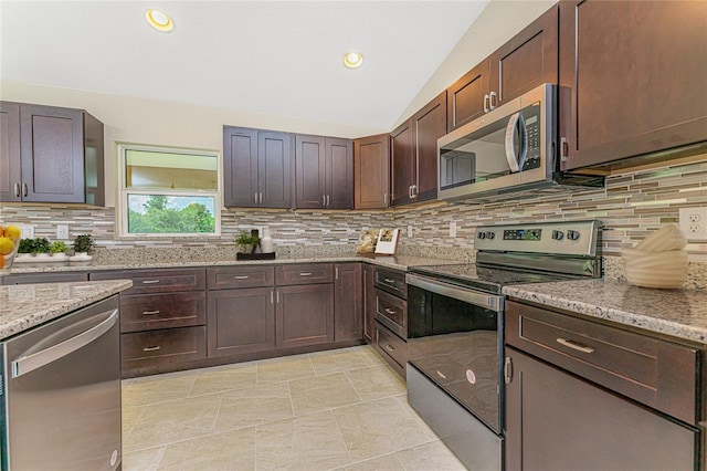 kitchen featuring stainless steel appliances, backsplash, light stone countertops, and vaulted ceiling