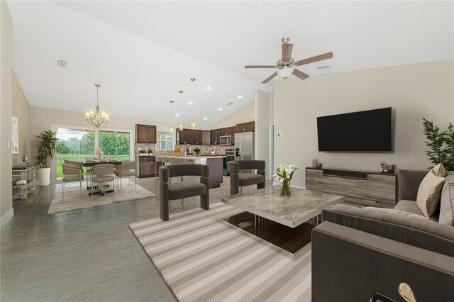 living room with ceiling fan with notable chandelier, sink, light tile patterned floors, and high vaulted ceiling