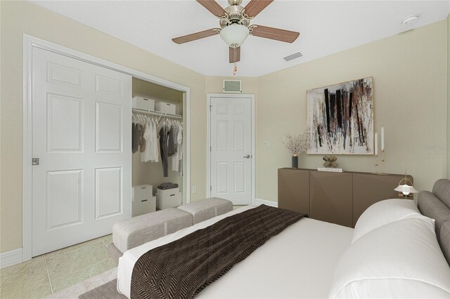 bedroom with tile patterned flooring, ceiling fan, and a closet