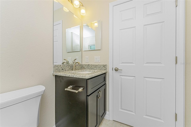 bathroom with tile patterned floors, vanity, and toilet