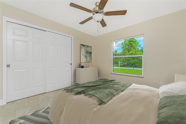 bedroom with a closet, tile patterned floors, and ceiling fan