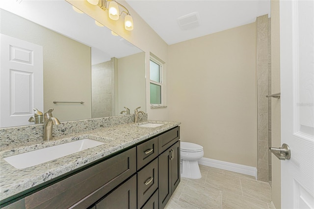 bathroom featuring toilet, tile patterned floors, and double sink vanity