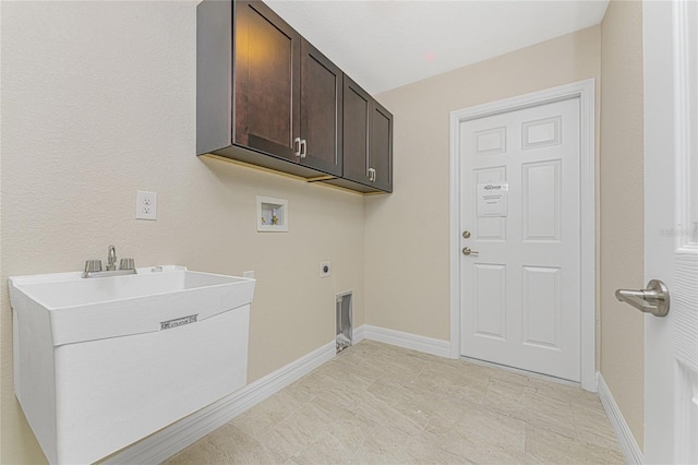 laundry area featuring electric dryer hookup, washer hookup, cabinets, and light tile patterned floors