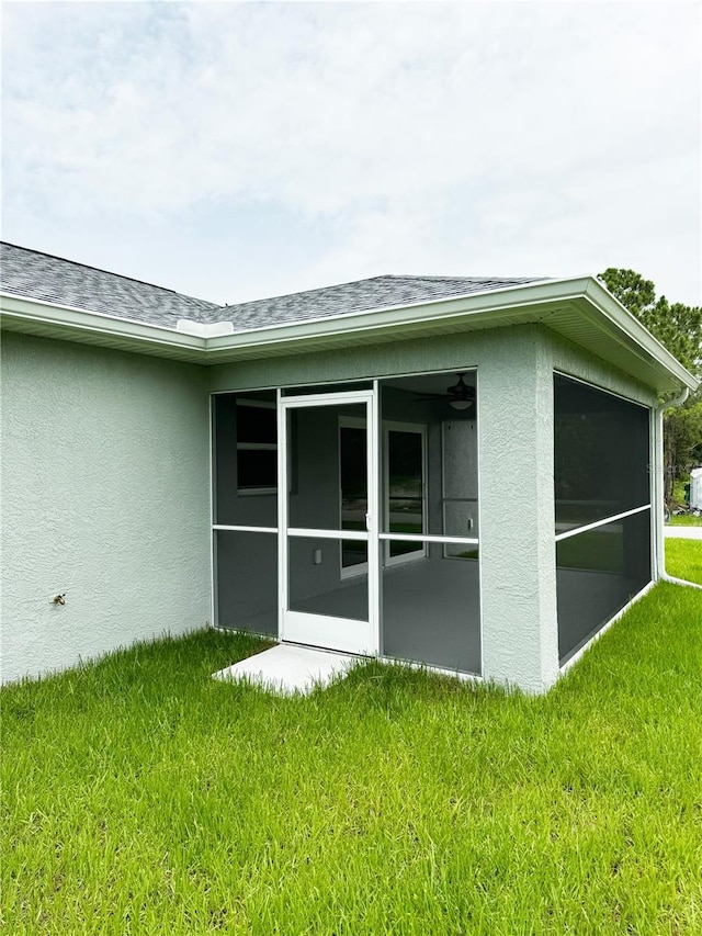 back of house featuring a sunroom and a lawn