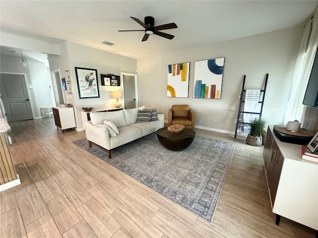 living room featuring hardwood / wood-style flooring, a textured ceiling, and ceiling fan