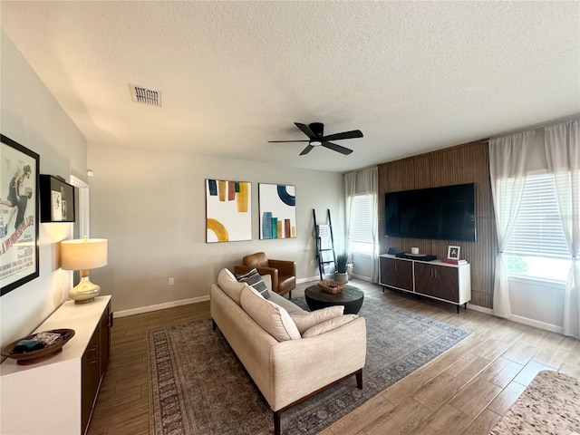 living room with hardwood / wood-style floors, a textured ceiling, and ceiling fan