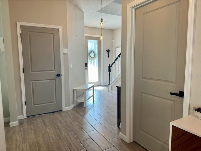 hall featuring a textured ceiling and light hardwood / wood-style flooring