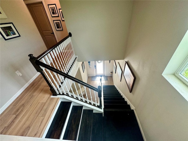 staircase featuring a healthy amount of sunlight and hardwood / wood-style floors