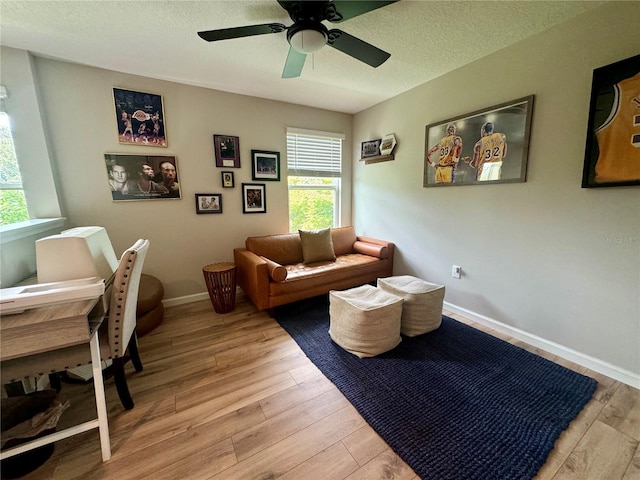 interior space featuring ceiling fan, a textured ceiling, and light wood-type flooring