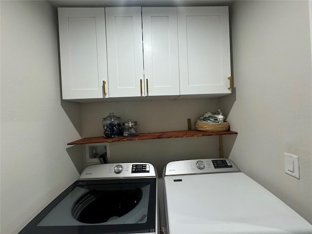 washroom with cabinets and washer and clothes dryer