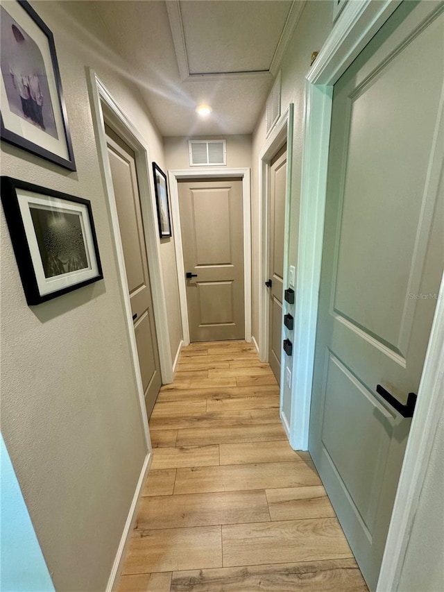 hallway with light hardwood / wood-style floors