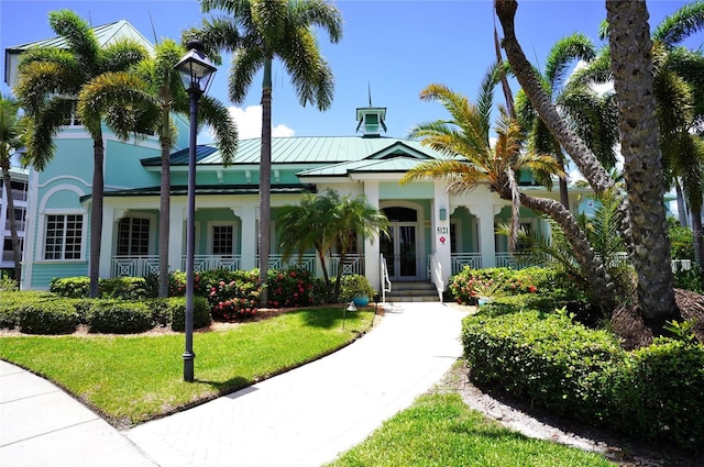 view of front of property featuring metal roof, a porch, a standing seam roof, and stucco siding