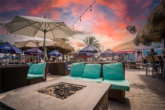 patio terrace at dusk featuring an outdoor living space with a fire pit