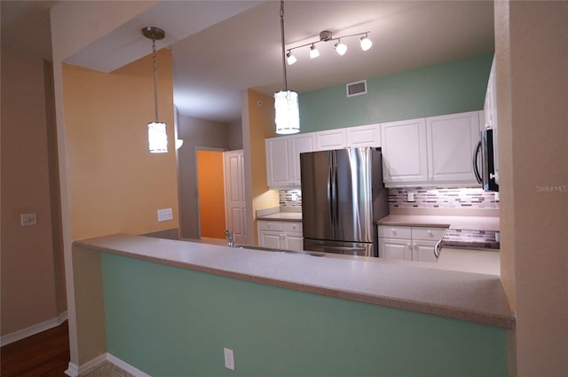 kitchen with dark wood-type flooring, white cabinets, stainless steel appliances, backsplash, and decorative light fixtures