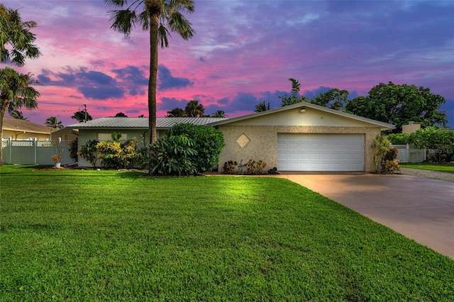 ranch-style home featuring a yard and a garage