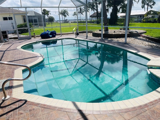 view of swimming pool featuring a patio area, a lawn, and glass enclosure